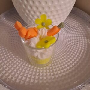 Handgefertigte Mini Osterkerze im Glas mit dekorativem Sahnehäubchen aus weißem Sojawachs für die Osterdekoration.